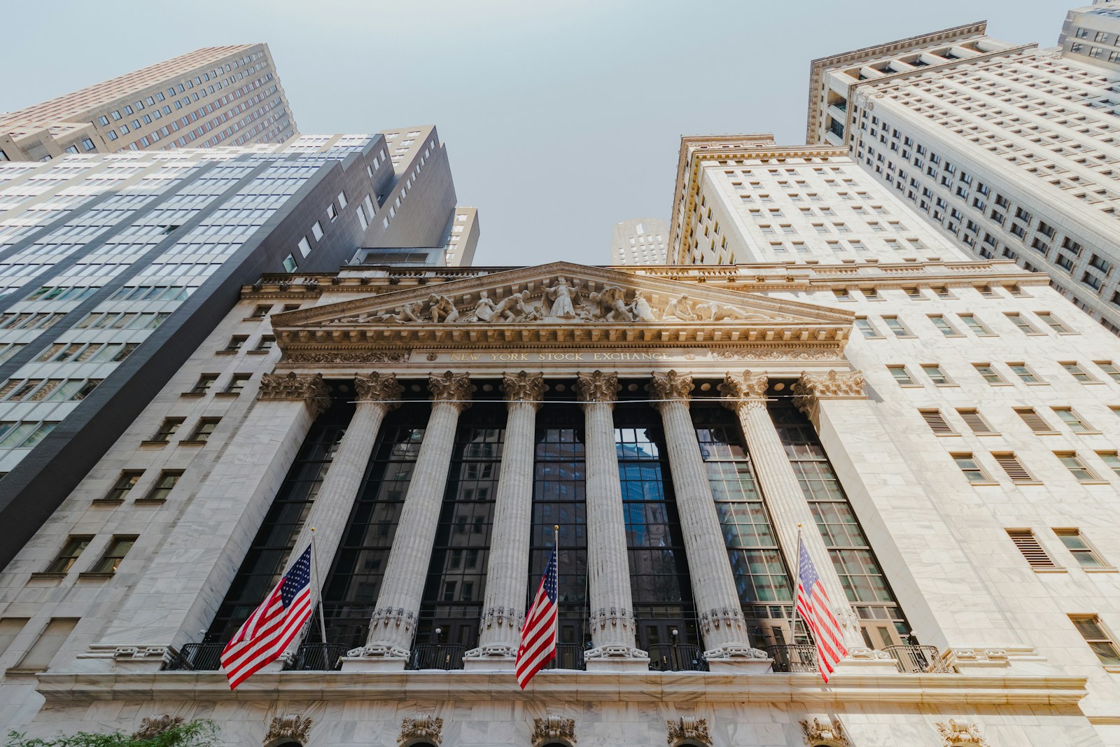 The New York Stock Exchange facade, with Corinthian columns and American flags, photographed in August 2024.